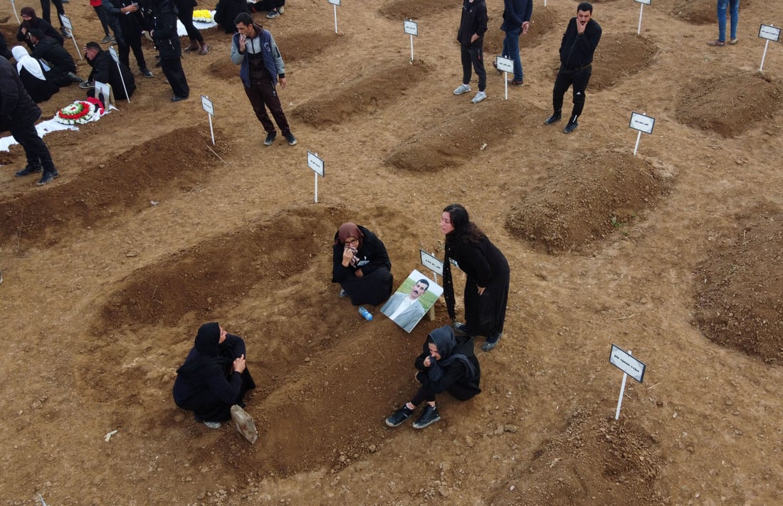 FILES PHOTO An aerial picture shows mourners gathering around graves during a mass funeral for Yazidi victims on Feb 6, 2021. (Photo by Zaid AL-OBEIDI / AFP)