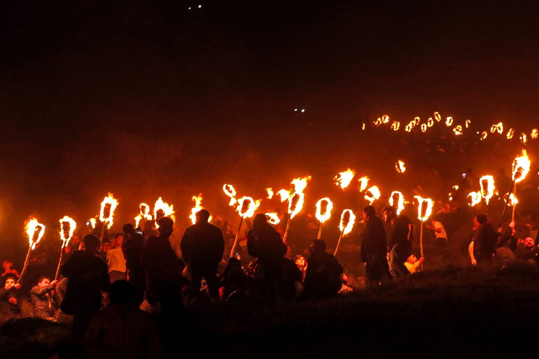Iraqi Kurds march with torches during a procession to celebrate the Nowruz New Year festival in the town of Akre (Photo by Safin HAMID/AFP)