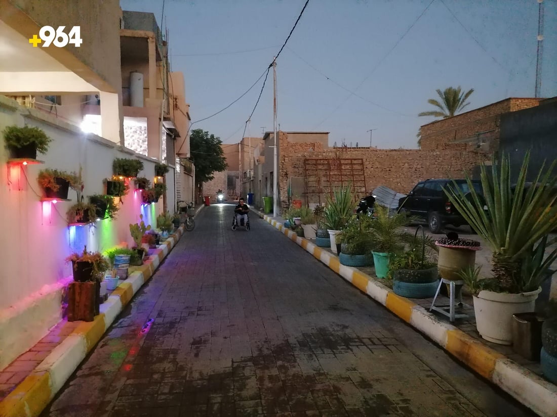 على كرسي متحرك.. ثلاثيني يزيّن شارعاً في هيت بالإنارة والمظلات والصبار (صور)