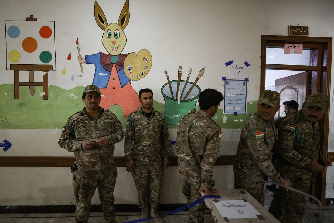 Members of the Kurdish Peshmerga security forces queue at a polling (Photo by AHMAD AL-RUBAYE / AFP)