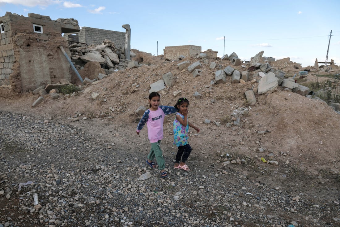 Iraqi Yazidi children walk near buildings destroyed during the 2014 attack. May 6, 2024 (Photo by Safin HAMID / AFP)