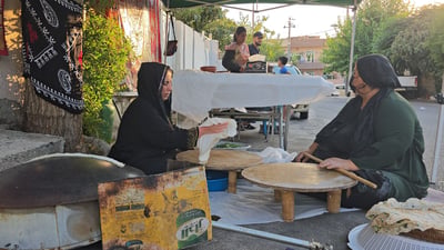 هەلیکار لەبەردەرگا؛ دایک و کچێک لەبەردەرگا کولێرەى کوردەوارى دروست دەکەن