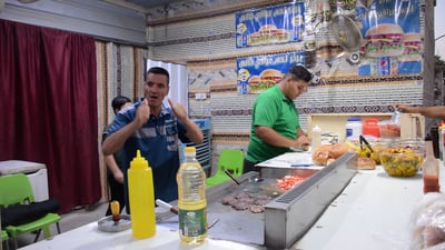 الأب يعد الهمبركر والابن يترجم.. أصم وأبكم يقدم طعاماً لذيذاً للزبائن في بلد (فيديو)