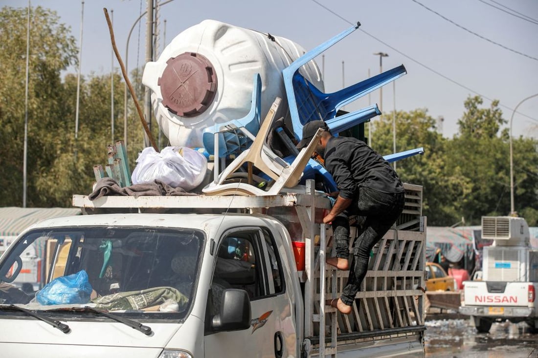 Plastic chairs and a water cistern used by supporters of Shiite Muslim cleric Moqtada al-Sadr are transported away as their encampment in Baghdad's high-security Green Zone is dismantled on August 30, 2022. - Members of the Sadrist faction began withdrawing from Baghdad's Green Zone on August 30 after their leader demanded fighting end between rival Shiite forces and the army that left 23 dead and hundreds wounded. (Photo by AHMAD AL-RUBAYE / AFP) (Photo by AHMAD AL-RUBAYE/AFP via Getty Images)