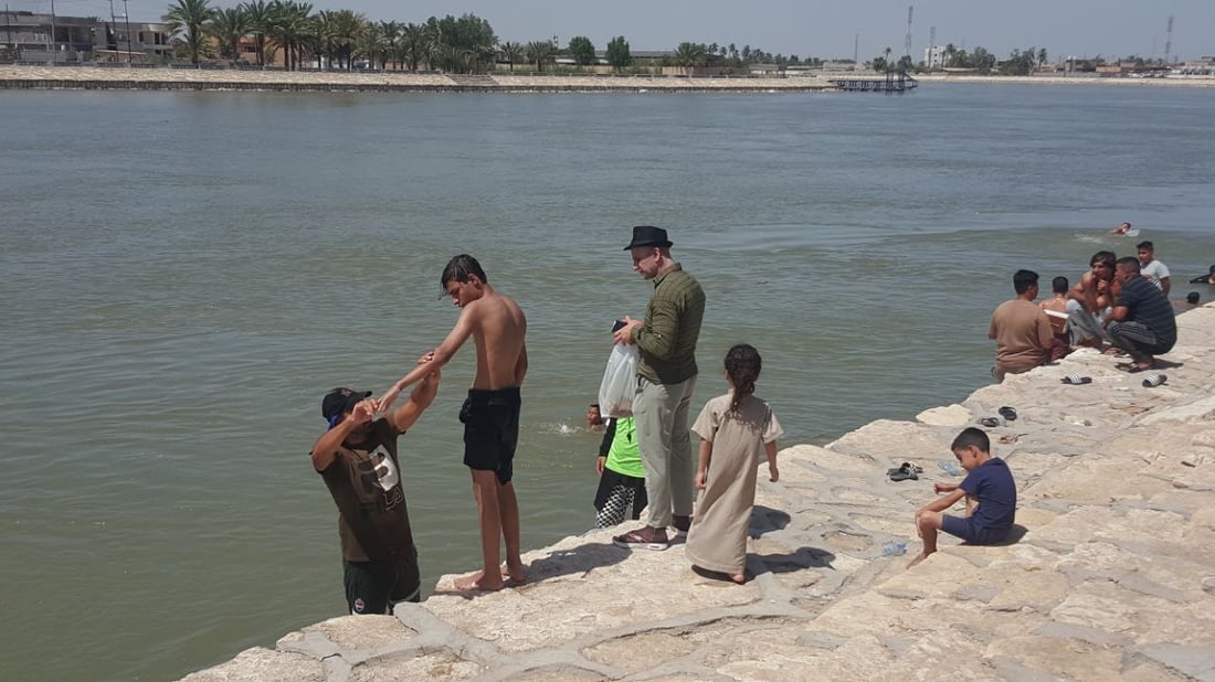 على شط المسيب ومع برودة الفرات.. سباح دولي يدرب الأطفال (صور)