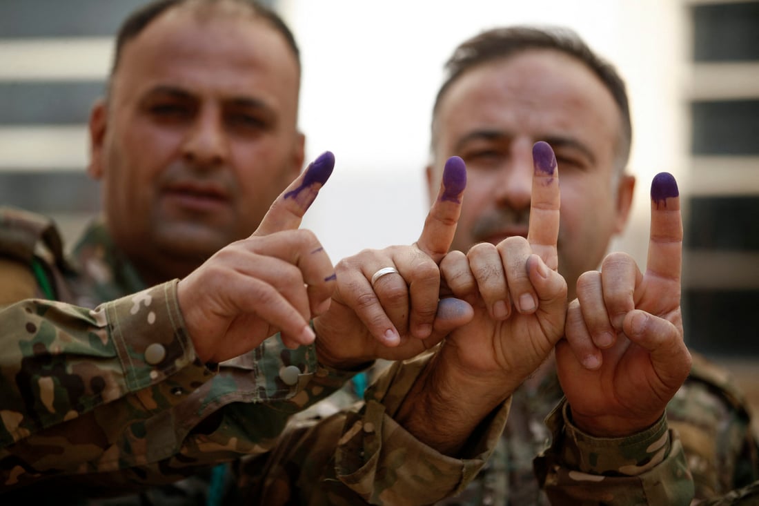 Members of the Kurdish Peshmerga security forces show their ink-stained fingers after casting their ballots ahead of the Oct. 20 (Photo by Ahmad Al-rubaye / AFP)