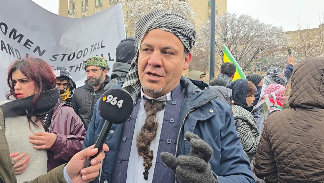 رۆژنامەنووسێک پرچێکی لەمل کردووە و چووەتەناو خۆپیشاندەران