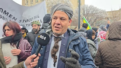 رۆژنامەنووسێک پرچێکی لەمل کردووە و چووەتەناو خۆپیشاندەران