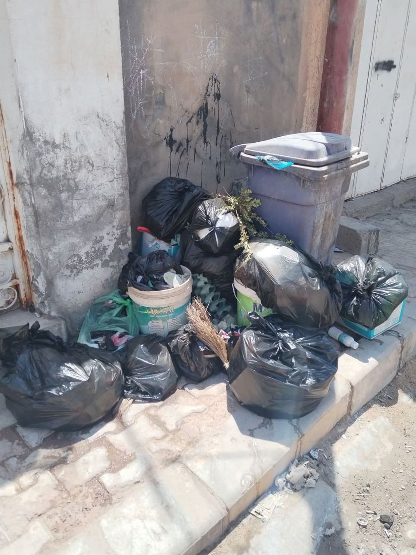 Garbage piles up in Al-Qala’a Al-Salih town as sanitation workers strike over unpaid wages