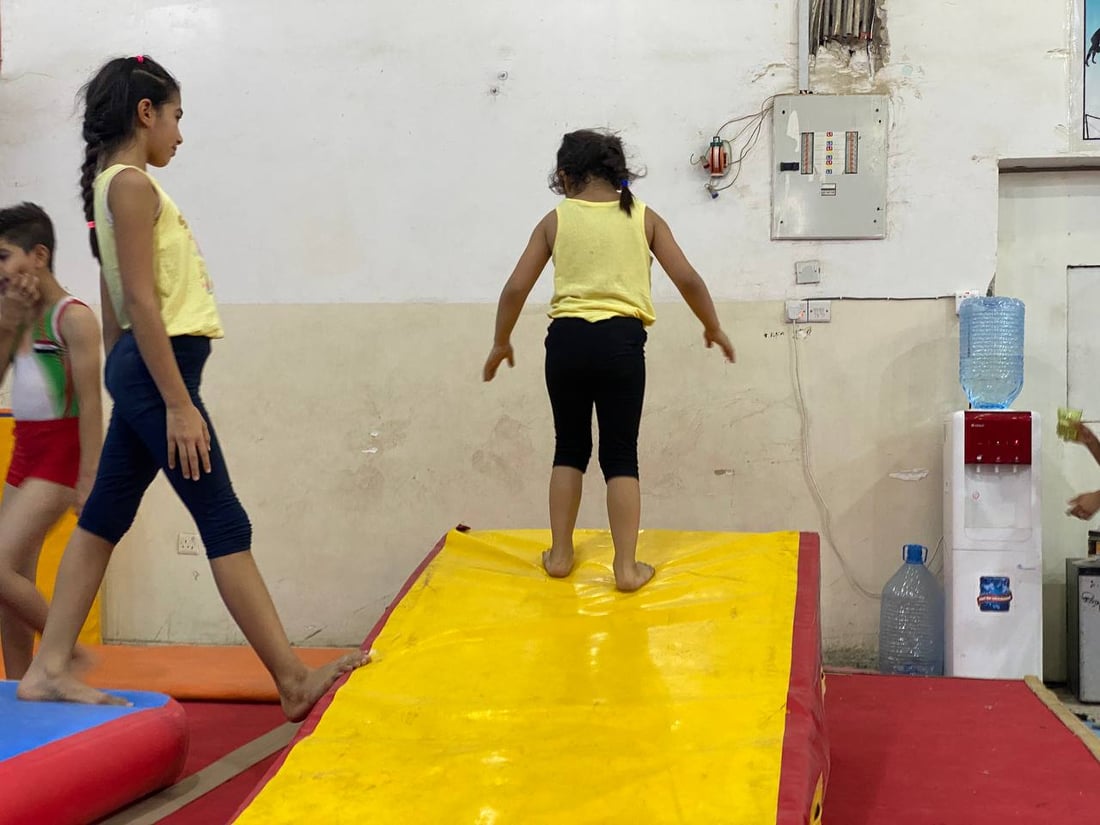 كابتن نوار يدرب أطفال البصرة لذهبية آسيا.. مرح وقساوة في قاعة الجمباز (فيديو)