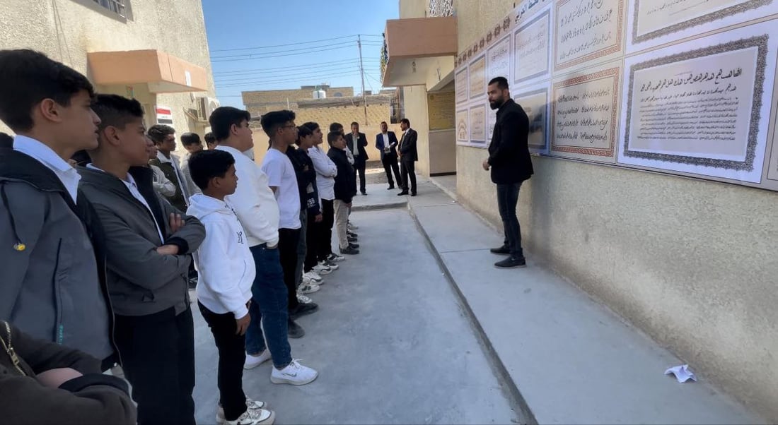 صور: مدرّس شاب في سوق الشيوخ رسم 8 أنواع من الخط العربي على جدارية كبيرة