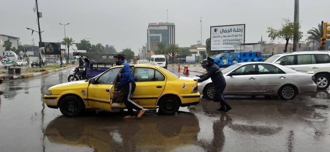 صور: رجال المرور في بغداد أمام مهمة شاقة تحت زخّ الأمطار