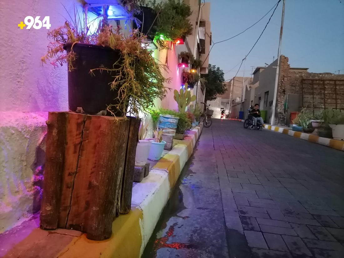 على كرسي متحرك.. ثلاثيني يزيّن شارعاً في هيت بالإنارة والمظلات والصبار (صور)