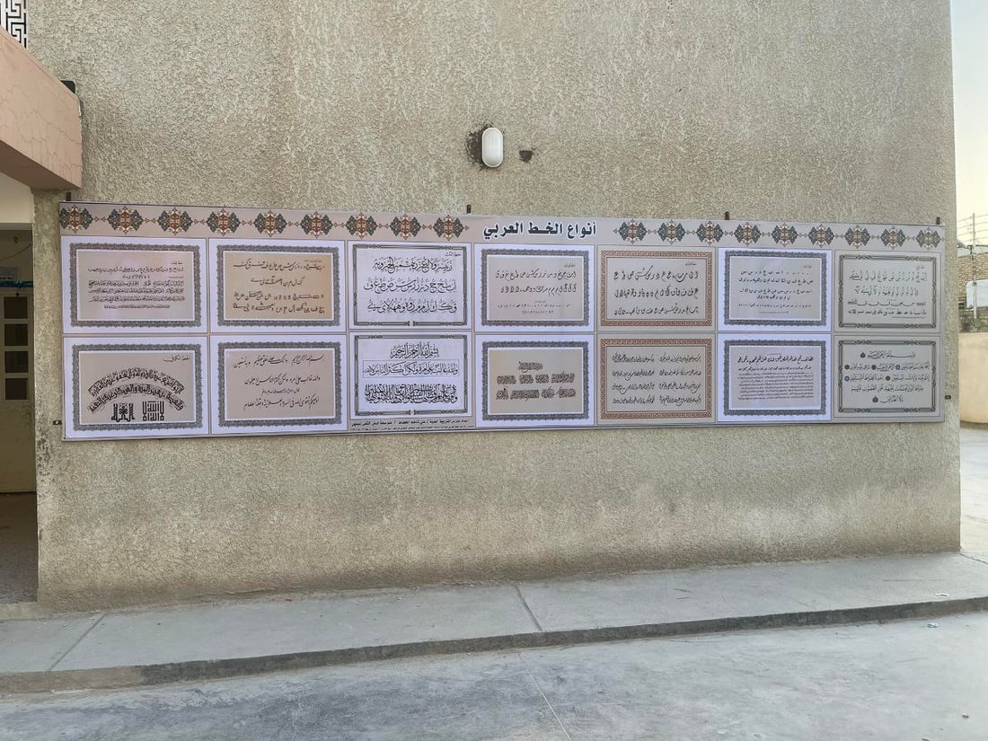 صور: مدرّس شاب في سوق الشيوخ رسم 8 أنواع من الخط العربي على جدارية كبيرة