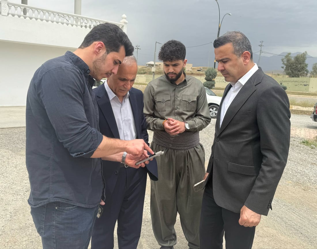 نالى کە جل و بەرگى کوردى لەبەرکردووە لەم وێنەیە لە نێوان قائیمقام و سەرۆکى شارەوانى قەڵادزێ دەرکەوتووە