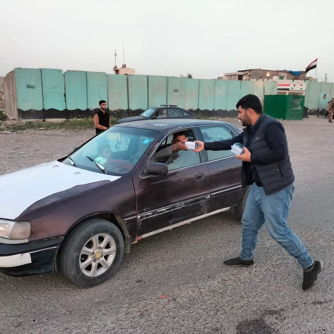 کۆمەڵێک گەنجی خۆبەخش لە رێگای کەرکوک بۆ بەغدا خواردن و ئاو دەدەن بە رێبواران