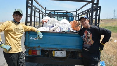 Teenagers collect roadside cans to earn a living, highlighting child labor reality in Iraq