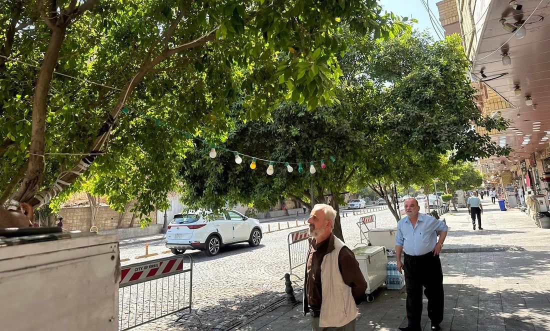 روناککەرەوە بە دار و درەختەکانی چواردەوری قەڵادا هەڵمەواسن