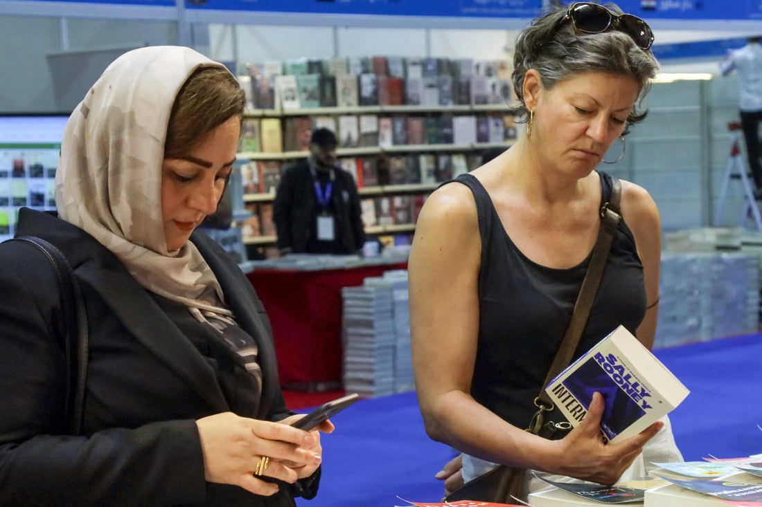 A visitor checks a book during the 17th Arbil International Book Fair, in the capital of the autonomous Kurdish region of northern Iraq, on April 9, 2025. (Photo by Safin HAMID / AFP)