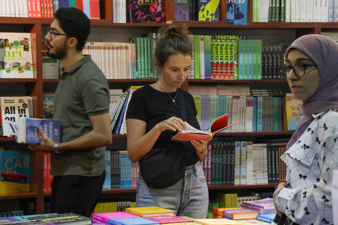 Visitors choose books during the 17th Arbil International Book Fair, in the capital of the autonomous Kurdish region of northern Iraq, on April 9, 2025. (Photo by Safin HAMID / AFP)