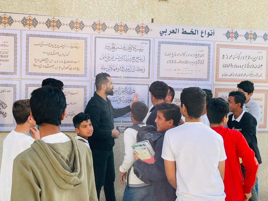 صور: مدرّس شاب في سوق الشيوخ رسم 8 أنواع من الخط العربي على جدارية كبيرة