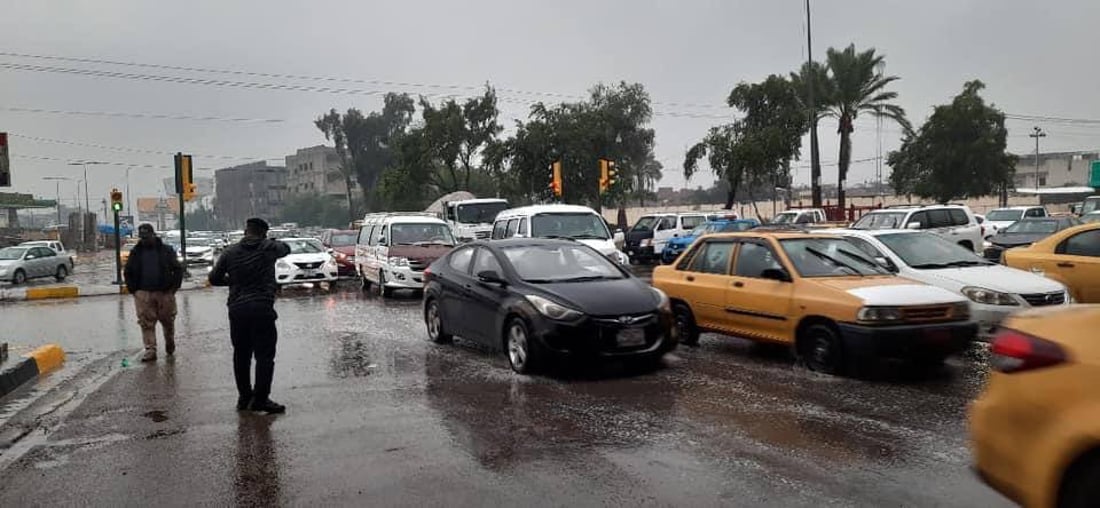 صور: رجال المرور في بغداد أمام مهمة شاقة تحت زخّ الأمطار