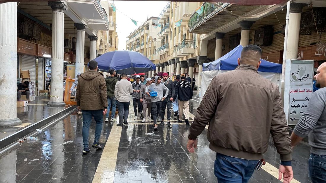 صور من حياة الشارع في بغداد: اليوم الأول لارتداء “القمصلة” وحمل مظلات المطر