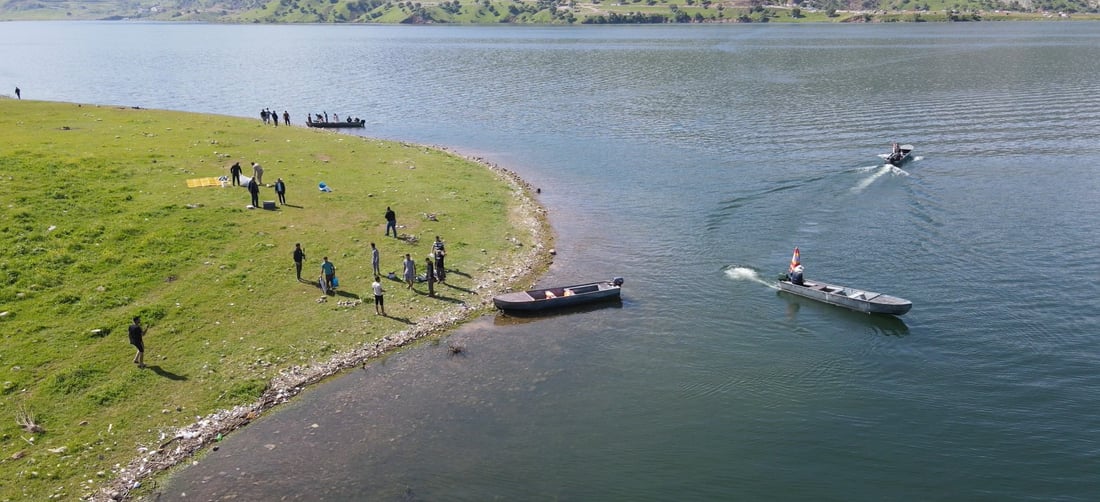 بە بەلەم پیاسە بە دەریاچەکەدا دەکەن