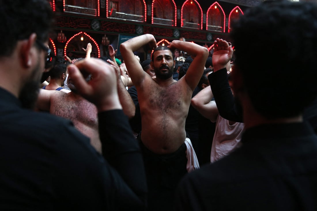 Shiite Muslim devotees perform a mourning ritual at the shrine of Imam Abu Al-Fadl Al-Abbas in Iraq's central holy city of Karbala (Photo by Mohammed SAWAF / AFP)