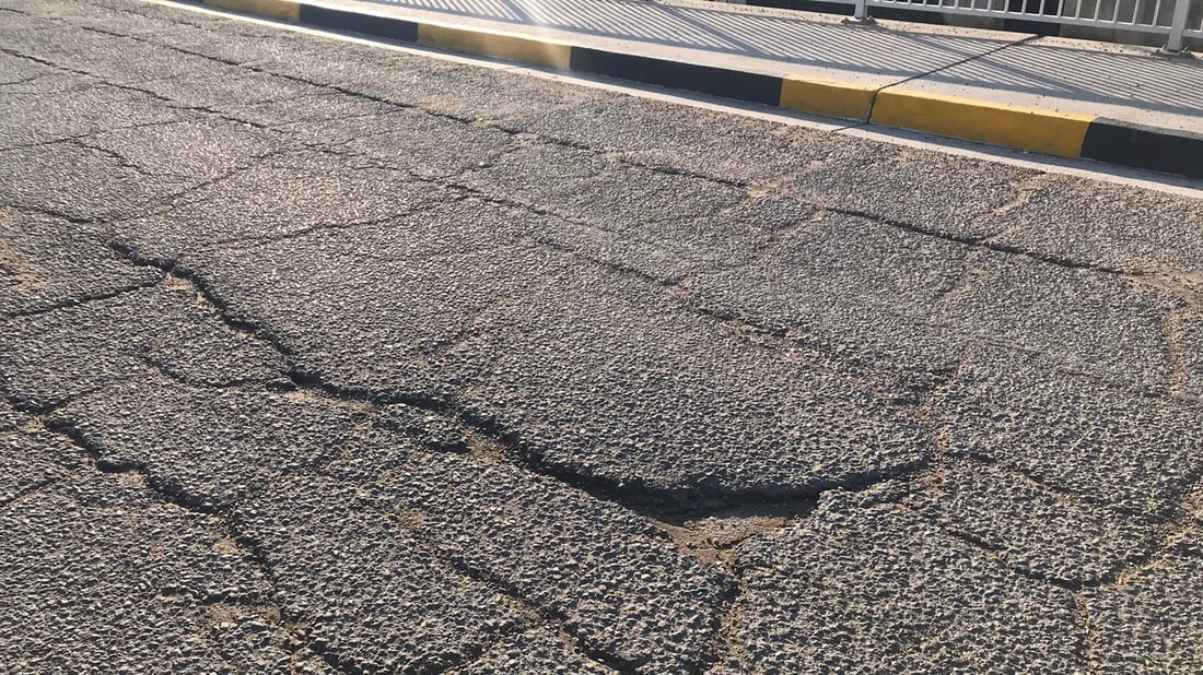 “الطسات” تملأ مجسر السفارات إلى العامرية.. بلا تأهيل منذ عقود ووعد من الأمانة (صور)