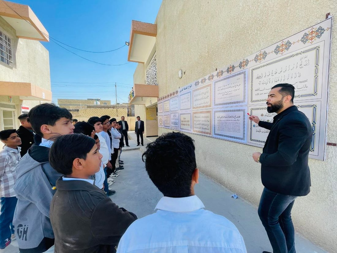 صور: مدرّس شاب في سوق الشيوخ رسم 8 أنواع من الخط العربي على جدارية كبيرة