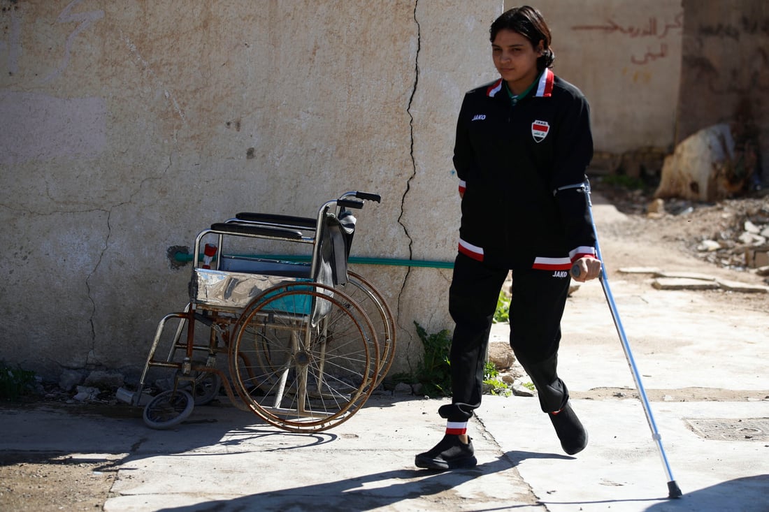 Iraqi paralympics table tennis athlete Najlah Imad, walks outside her house (Photo by Ahmad AL-RUBAYE / AFP)