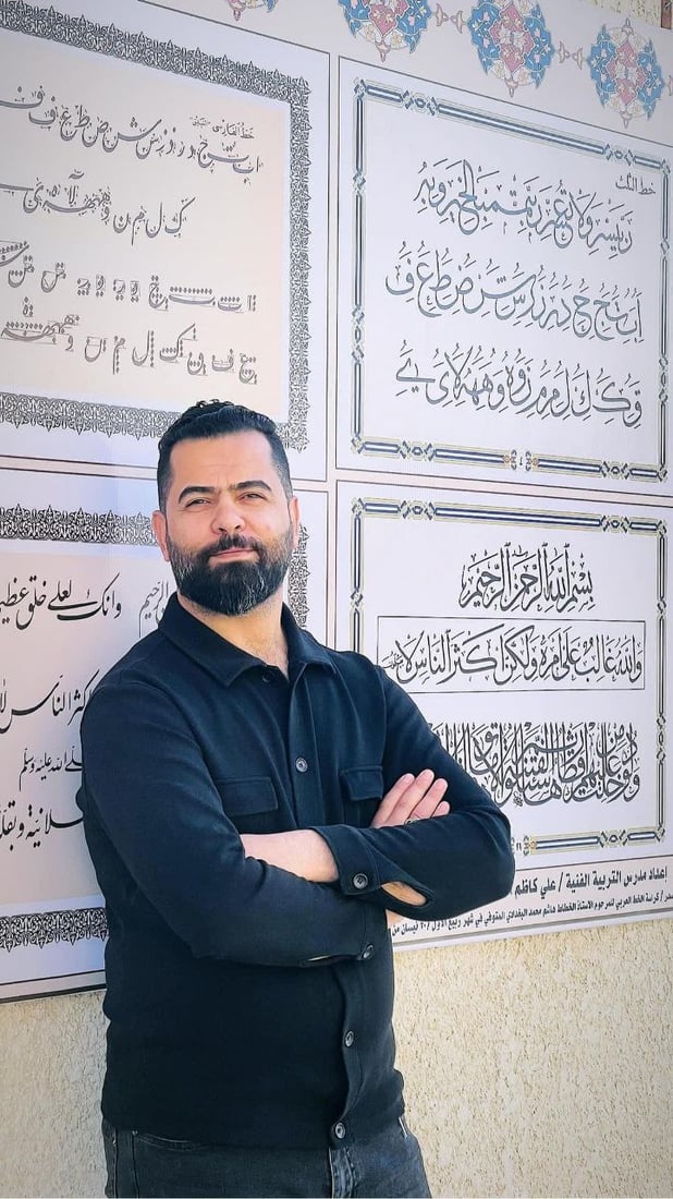 صور: مدرّس شاب في سوق الشيوخ رسم 8 أنواع من الخط العربي على جدارية كبيرة