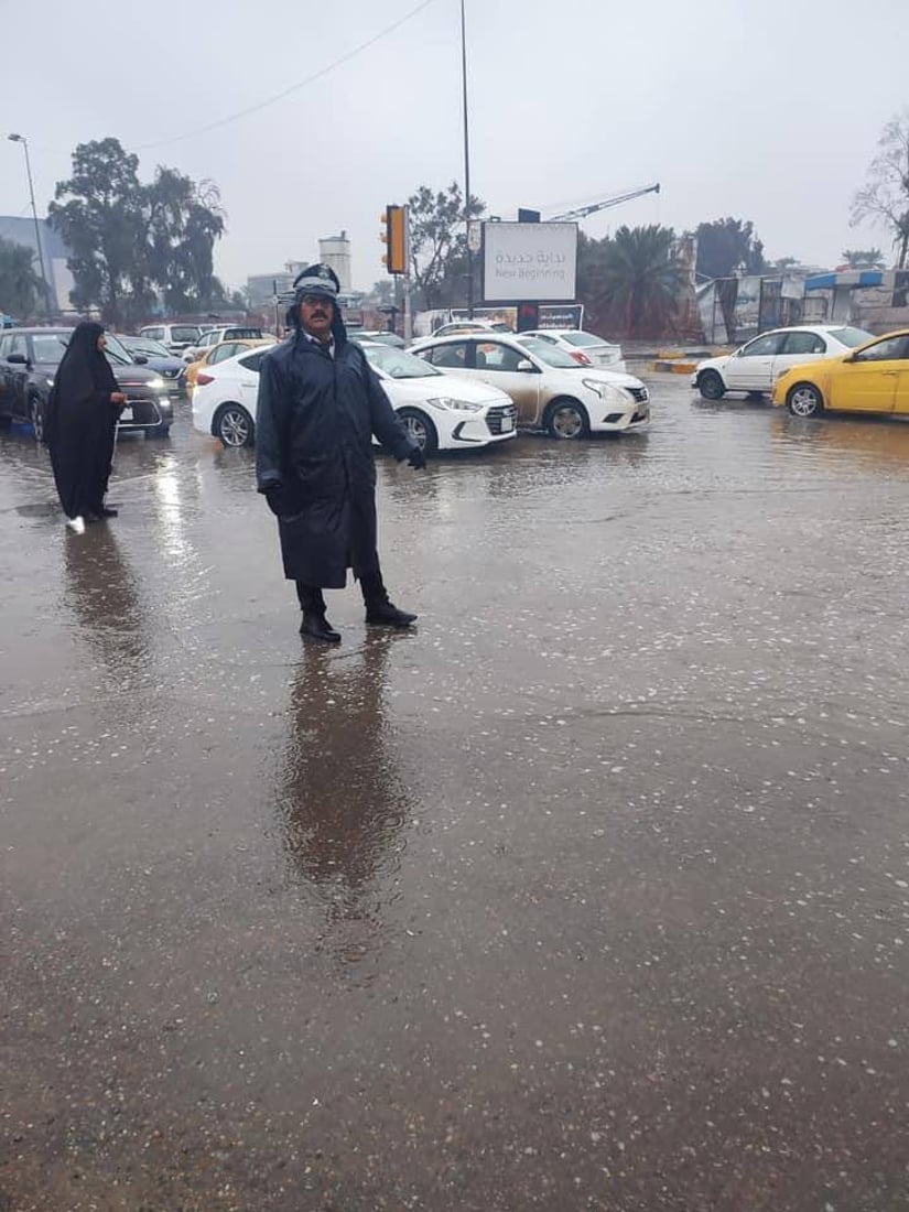 صور: رجال المرور في بغداد أمام مهمة شاقة تحت زخّ الأمطار