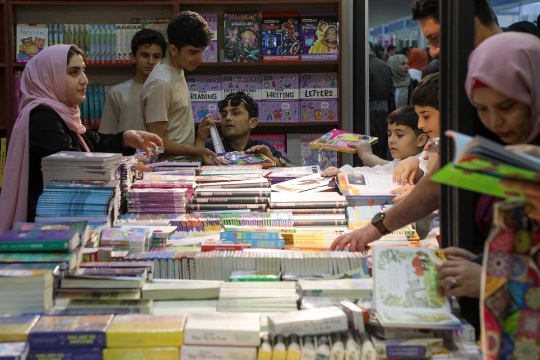 Visitors choose books during the 17th Arbil International Book Fair, in the capital of the autonomous Kurdish region of northern Iraq, on April 9, 2025. (Photo by Safin HAMID / AFP)