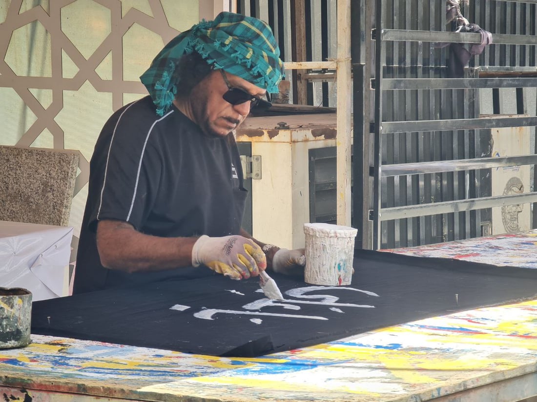 أصباغ أردنية تخط رايات الحسين في السماوة.. صور مع خطاطي شارع الجسر