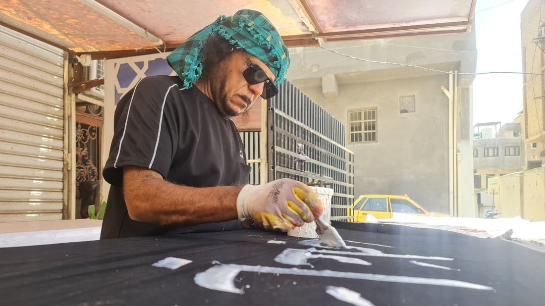 أصباغ أردنية تخط رايات الحسين في السماوة.. صور مع خطاطي شارع الجسر