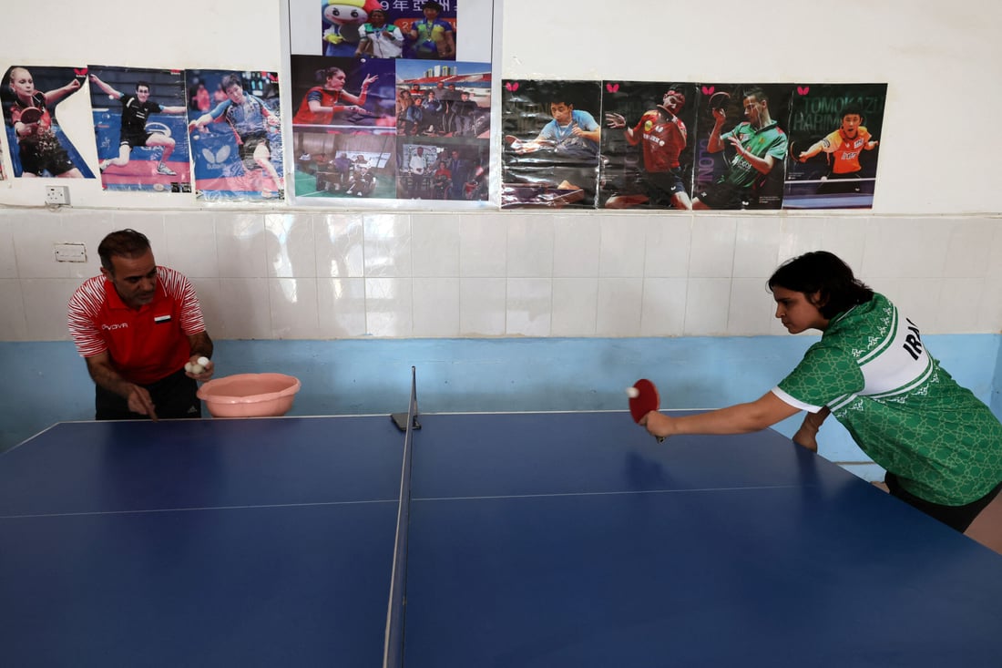 Iraqi paralympics table tennis athlete Najlah Imad (R), exercises at the Al-Mawaheb Club premises in Baqubah (Photo by Ahmad AL-RUBAYE / AFP)