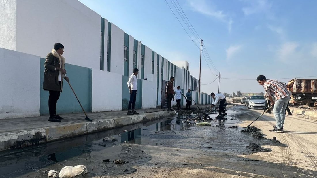 بابل: طلبة المدحتية سئموا الجدل بين البلدية والمجاري ونظفوا مدخل المدرسة (صور)
