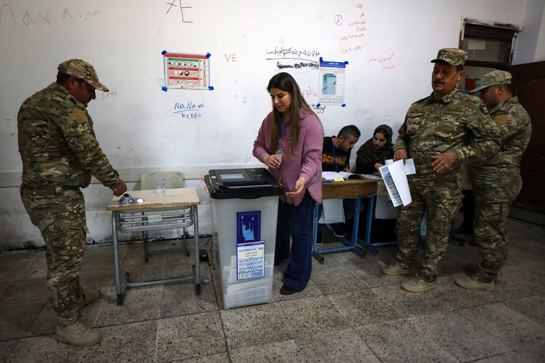 Members of the Kurdish Peshmerga security forces vote at a polling station (Photo by AHMAD AL-RUBAYE / AFP)