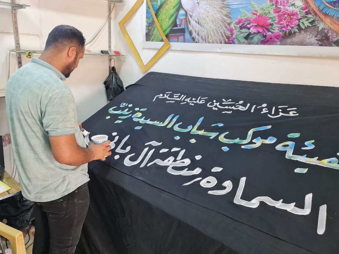 أصباغ أردنية تخط رايات الحسين في السماوة.. صور مع خطاطي شارع الجسر