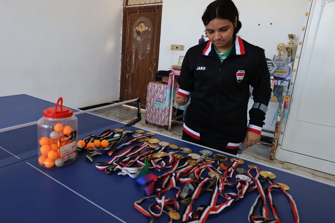 Iraqi paralympics table tennis athlete Najlah Imad, displays her medals at her house (Photo by Ahmad AL-RUBAYE / AFP)
