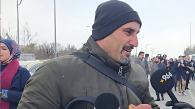 بە مایکەکەى دەستییەوە؛ بەکوڵ بۆ کەسوکارەکەى دەگرى