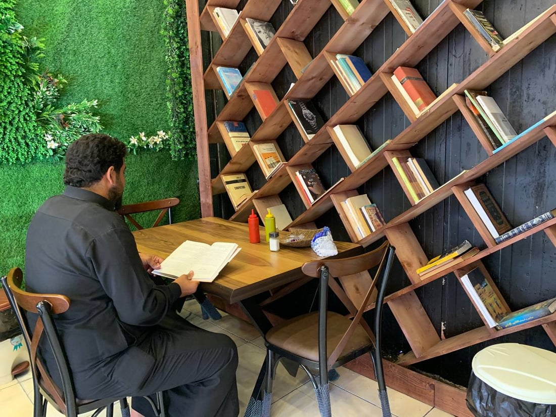 صور من الأعظمية: “الكردي” يسلّي المراجعين بالكتب ويطعمهم أكلات لذيذة
