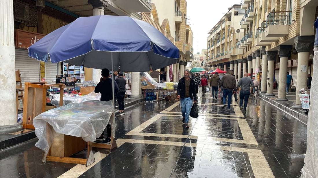 صور من حياة الشارع في بغداد: اليوم الأول لارتداء “القمصلة” وحمل مظلات المطر