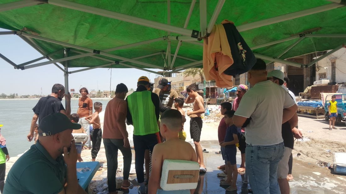 على شط المسيب ومع برودة الفرات.. سباح دولي يدرب الأطفال (صور)