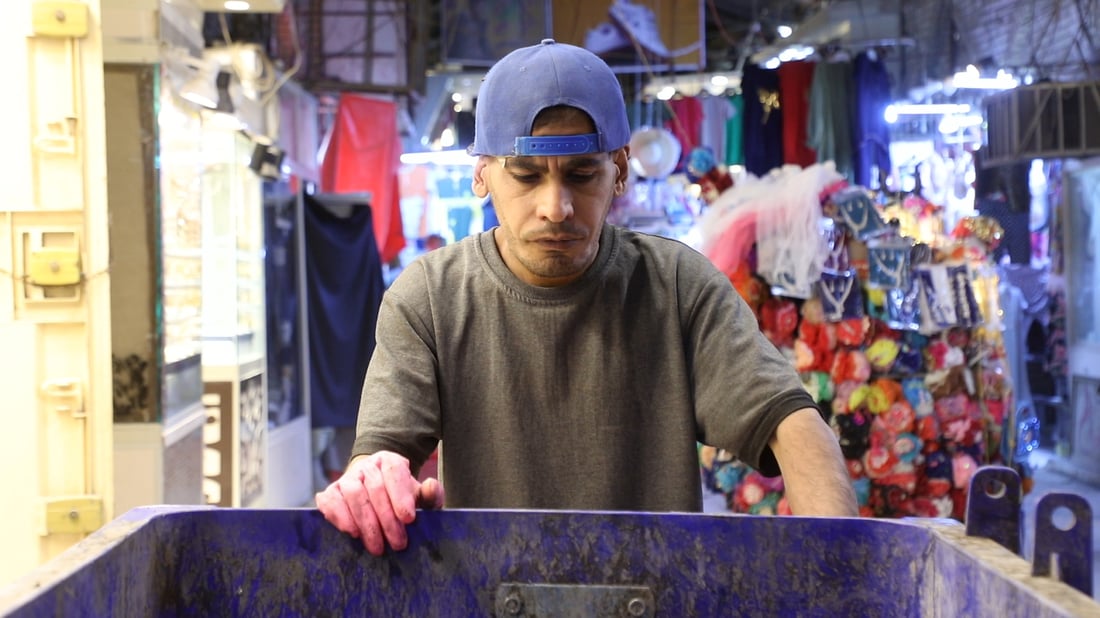 يتواصل بالإشارة ويعادل 5 عمال.. حيدر ينظف سوق الديوانية 4 سنوات بلا راتب (صور)