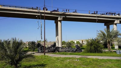 سائق شاحنة فقد السيطرة وسقط من أعلى الجسر الخامس في الموصل (صور)