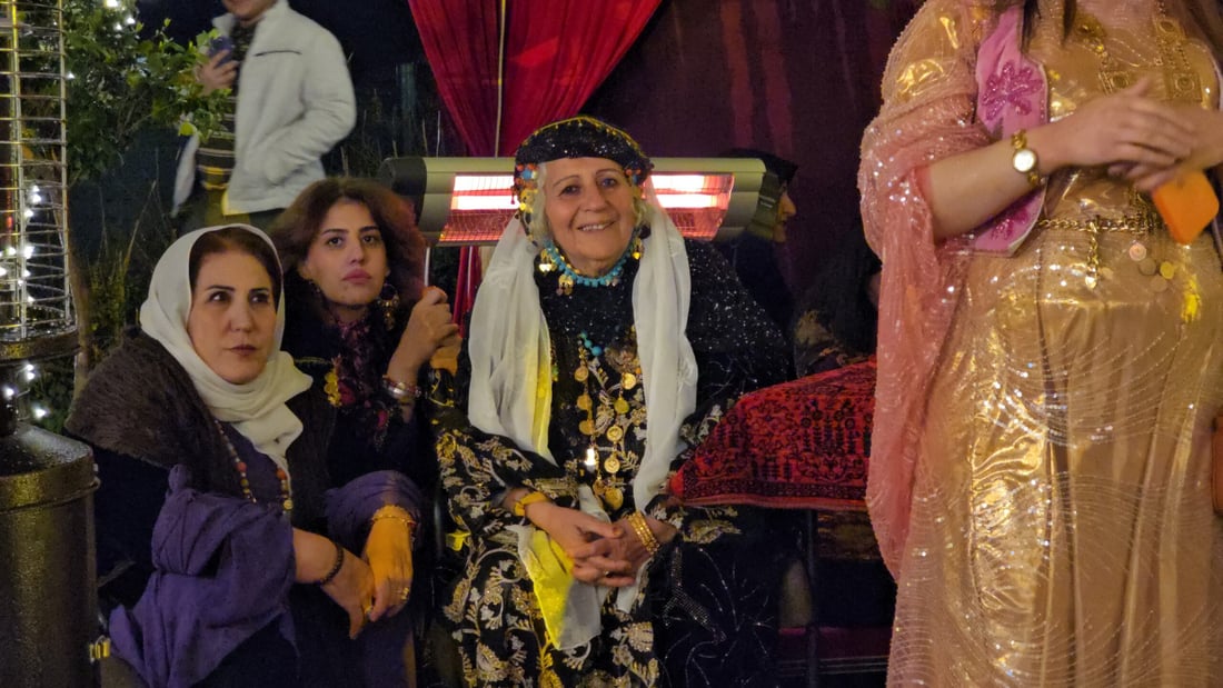 بارانە و گەنجان بە جلی کوردییەوە لە دەوری ئاگری نەورۆز کۆبوونەتەوە