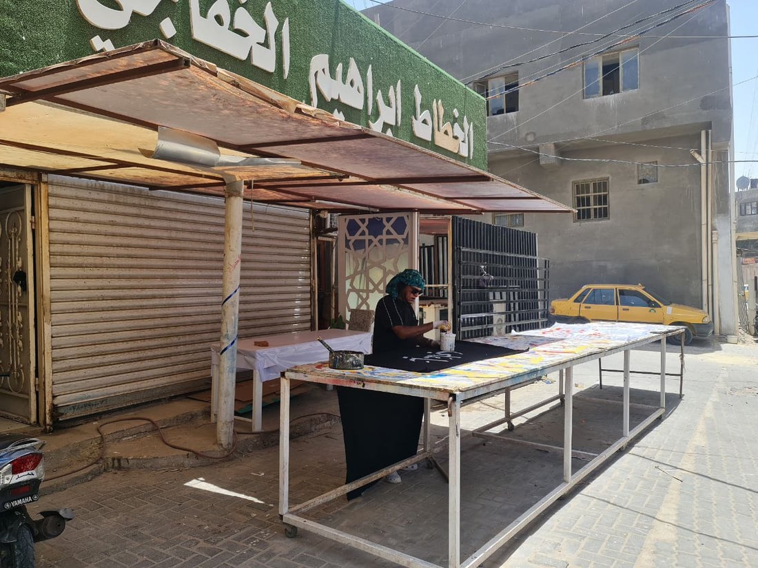 أصباغ أردنية تخط رايات الحسين في السماوة.. صور مع خطاطي شارع الجسر